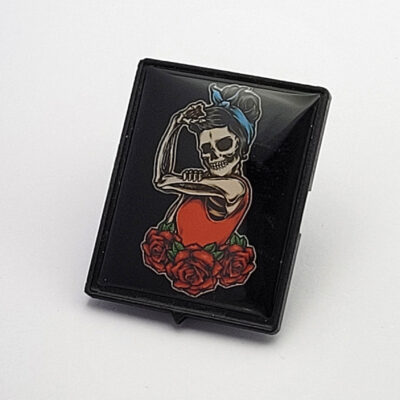 3D-Vespa-Emblem mit Skull-Girl-Pin-up-Motiv, rotem Kleid, blauer Kopfbinde und roten Rosen auf schwarzem Hintergrund.