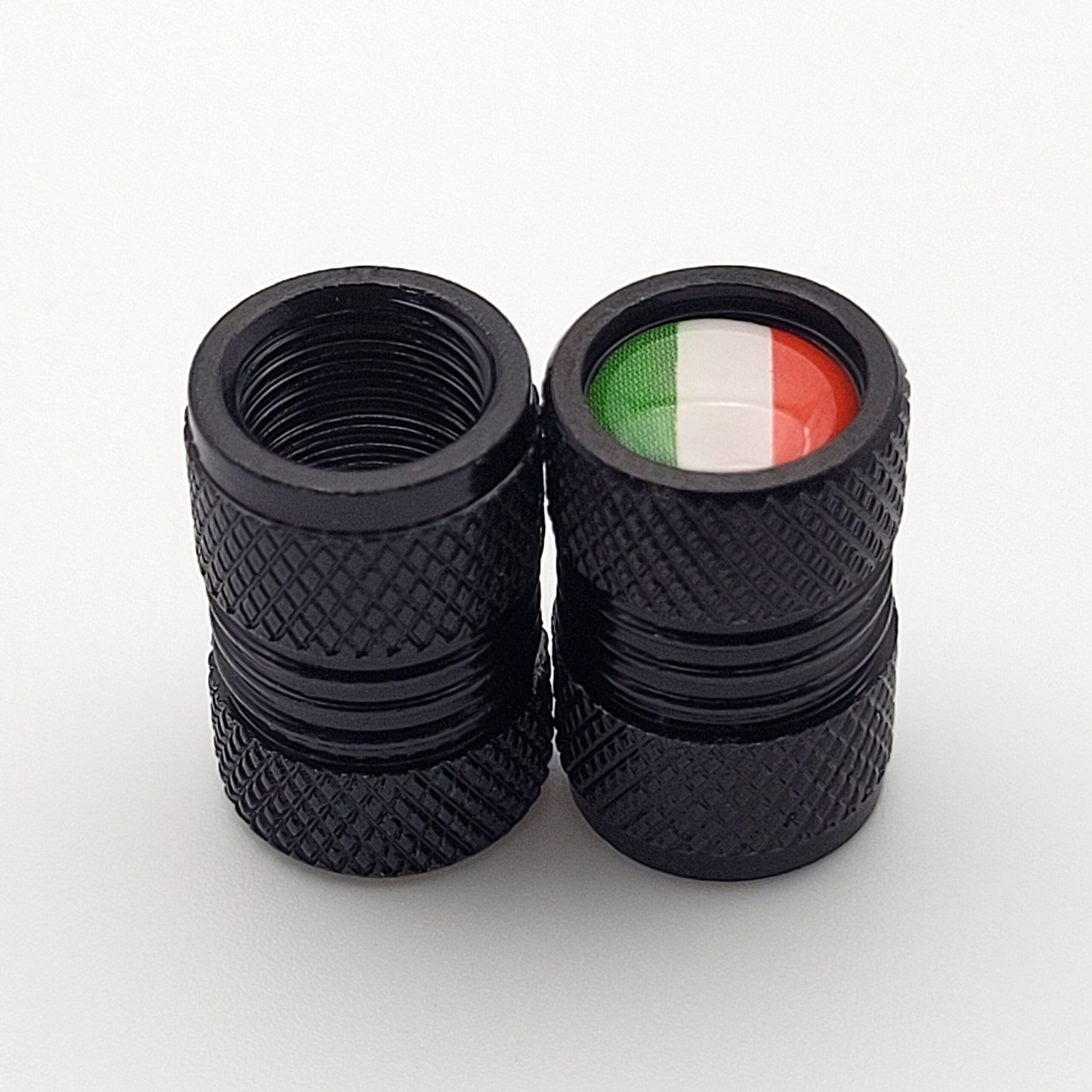 Zwei schwarze Vespa Ventilkappen mit italienischer Flagge und griffiger Rautenstruktur auf weißem Hintergrund.